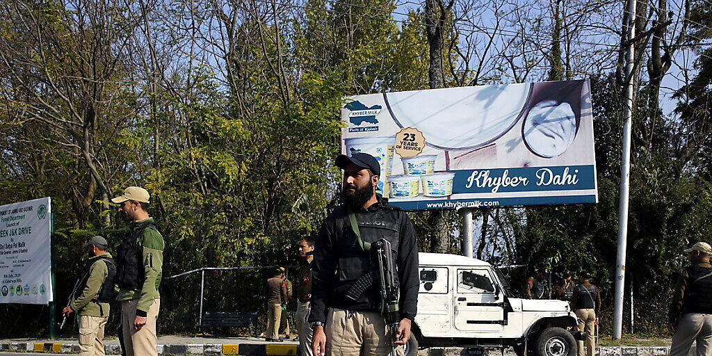 Indische Polizisten stehen an einer Strasse in Srinagar Wache, die zum Regierungsgebäude führt. Dort legte der neue Gouverneur von Jammu und Kaschmir den Amtseid ab.