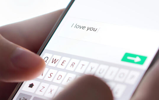 Romance fraud, scam or deceit with smartphone. Man writing comment.