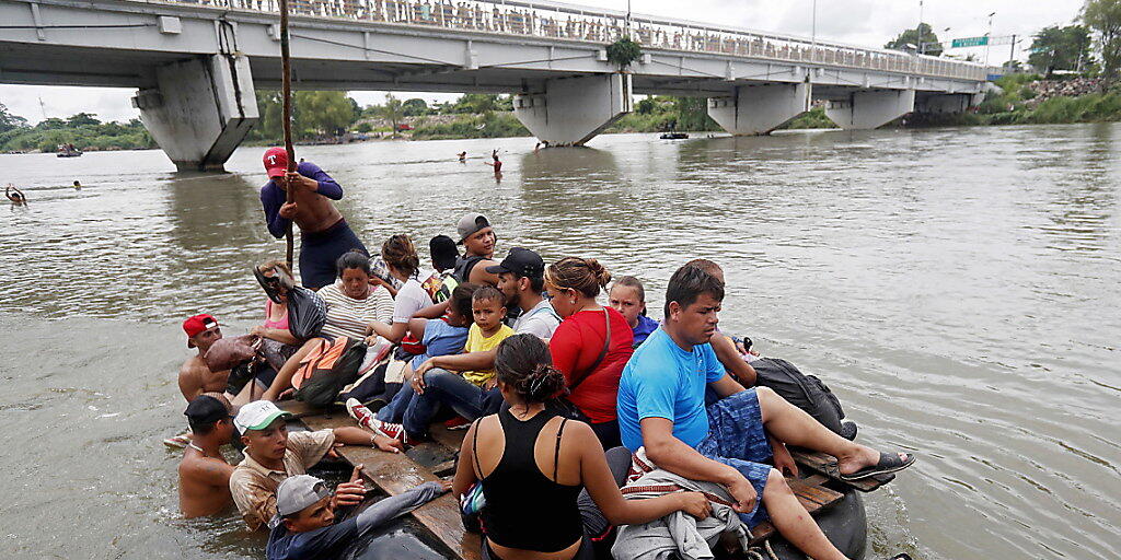 Hoffnung auf ein besseres Leben: Tausende Migranten aus Honduras versuchen via Mexiko in die USA zu gelangen. Viele versuchen, den Grenzpolizisten auf der Brücke mit dem Weg durchs Wasser auszuweichen.