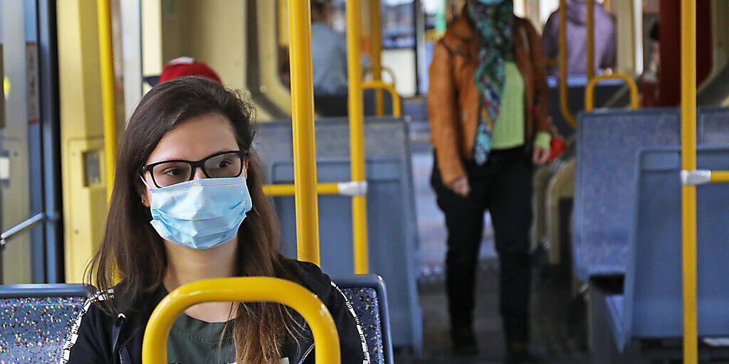 ARCHIV - Fahrgäste sitzen mit Schutzmasken in einer Kölner Straßenbahn. Foto: Oliver Berg/dpa