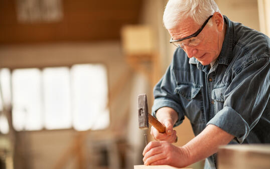 Mature carpenter using hammer