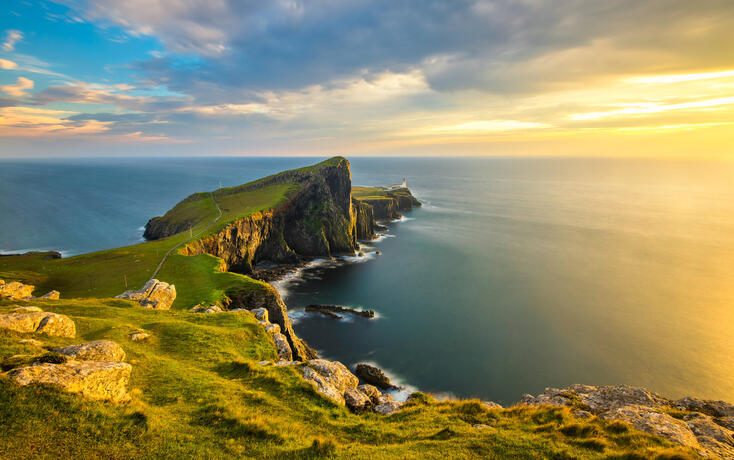 Beautiful golden light at sunset at Neist Point Lighthouse on the Isle of Skye, Scotland.