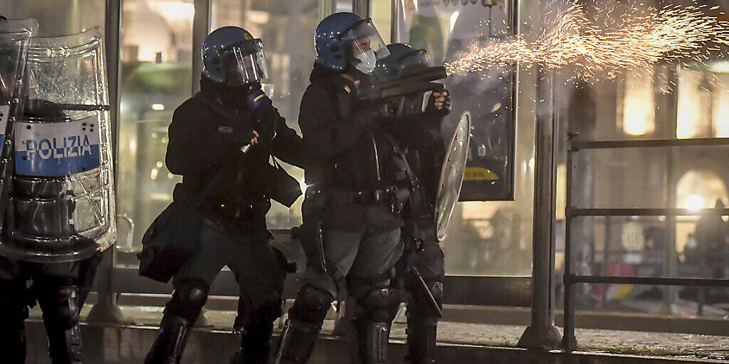 Polizisten setzen während eines Protests gegen die Corona-Maßnahmen der Regierung in Turin Tränengas ein. Foto: Claudio Furlan/LaPresse/AP/dpa