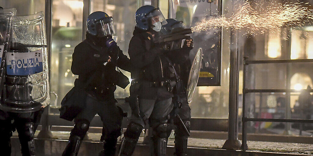Polizisten setzen während eines Protests gegen die Corona-Maßnahmen der Regierung in Turin Tränengas ein. Foto: Claudio Furlan/LaPresse/AP/dpa Polizisten setzen während eines Protests gegen die Corona-Maßnahmen der Regierung in Turin Tränengas ein. Foto: Claudio Furlan/LaPresse/AP/dpa