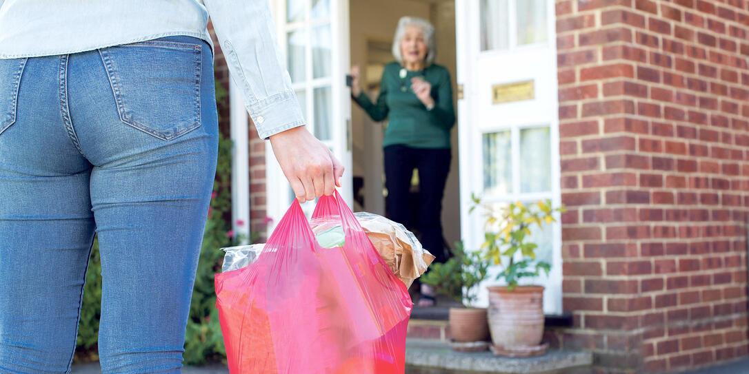 Close Up Of Woman Doing Shopping For Senior Neighbor
