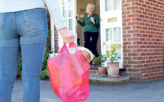 Close Up Of Woman Doing Shopping For Senior Neighbor