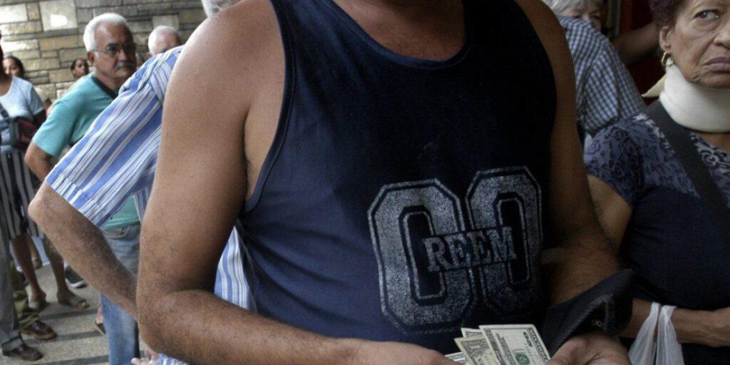 Ein Mann mit US-Dollars vor einer Wechselstube in der kubanischen Hauptstadt Havanna. (Archivbild)