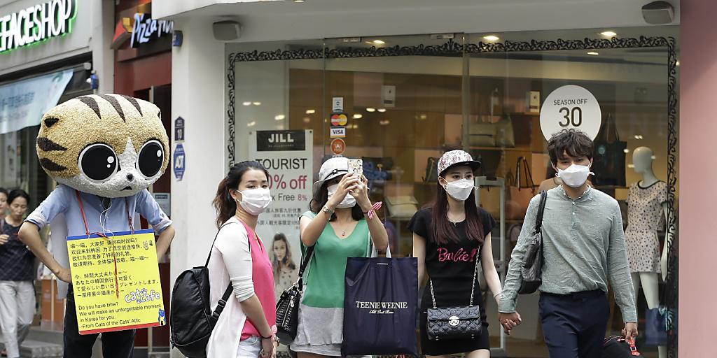 Trotzen dem Virus: Junge Menschen mit Masken im Einkaufsviertel Myeongdong in Südkoreas Hauptstadt Seoul Trotzen dem Virus: Junge Menschen mit Masken im Einkaufsviertel Myeongdong in Südkoreas Hauptstadt Seoul
