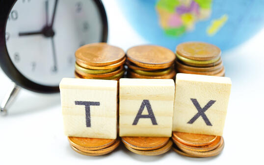 TAX alphabet with stack of coin and alarm clock : Time to pay.