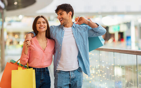 Happy Couple Hugging Doing Shopping Walking Together In Hypermarket