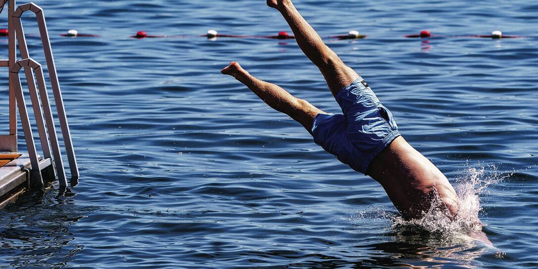 Schwimmer springt ins Wasser