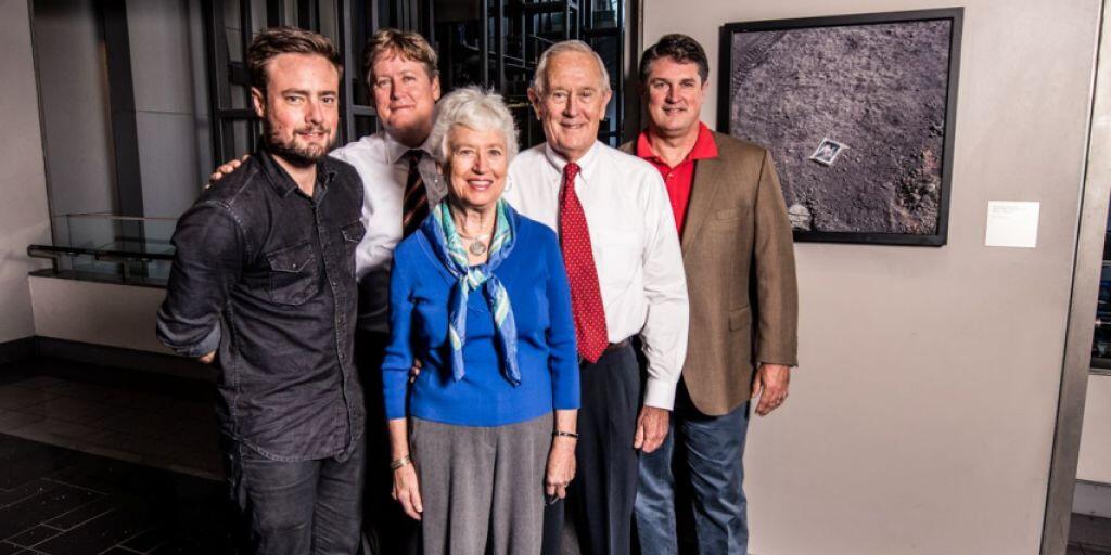 Astronaut Charlie Duke mit seiner Familie und Filmregisseur Rob Lewis vor dem berühmten Foto des Bildes der Duke-Familie, das der Amerikaner auf dem Mond zurückliess. Die Geschichte steht im Fokus des Films &ldquo;Lunar Tribute&rdquo; des Schweizer Flimmers Lewis.