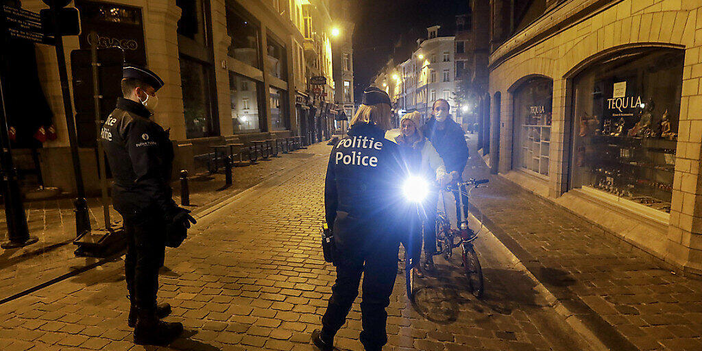Zwei Polizeibeamte patrouillieren zu Beginn der Ausgangssperre durch die Stadt. Die belgische Regierung führte strengere Maßnahmen ein, um das Risiko der Ausbreitung von Covid-19 zu verringern, da die Zahl der Covid-19-Infektionen stark ansteigt. Foto: Thierry Roge/BELGA/dpa