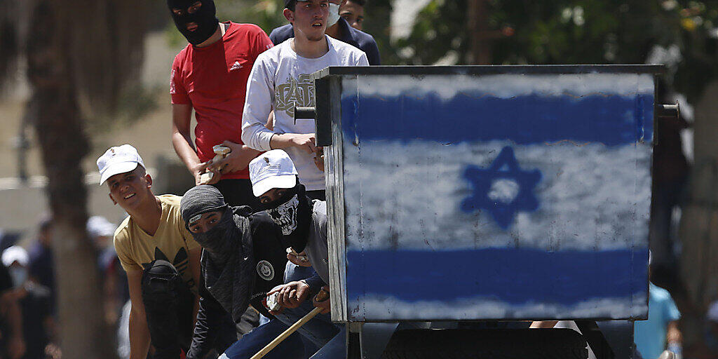 Palästinensische Demonstranten schleudern Steine auf israelische Truppen während eines Protests in Kufr Qaddum gegen Israels Plan, Teile des Westjordanlandes zu annektieren. Foto: Majdi Mohammed/AP/dpa