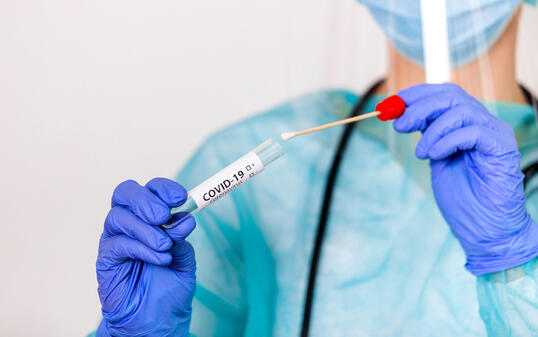 Lab technician holding swab collection kit,Coronavirus COVID-19 specimen collecting equipment,DNA nasal and oral swabbing for PCR polymerase chain reaction laboratory testing procedure and shipping