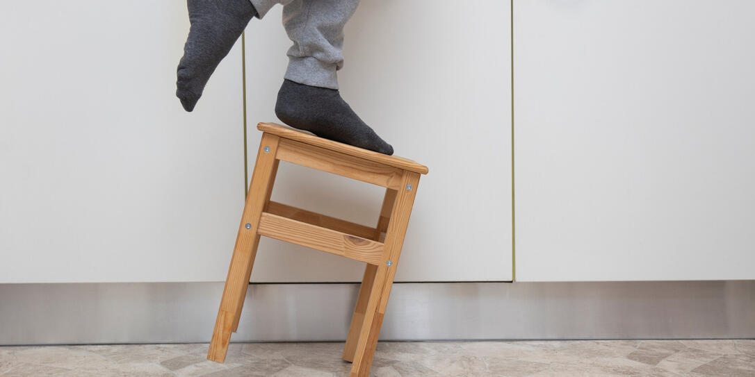 A man falls off a small kitchen ladder