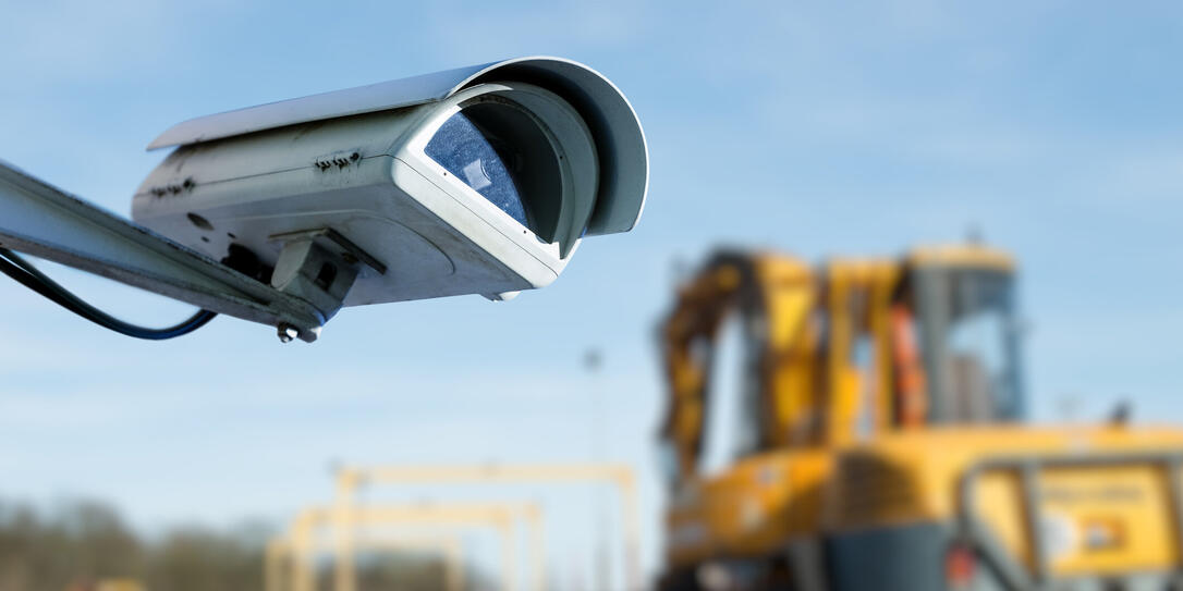 security CCTV camera or surveillance system with industrial site on blurry background
