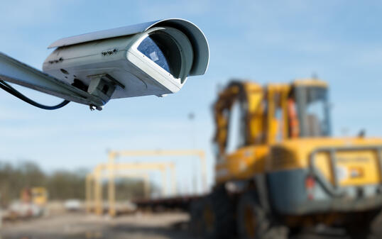 security CCTV camera or surveillance system with industrial site on blurry background