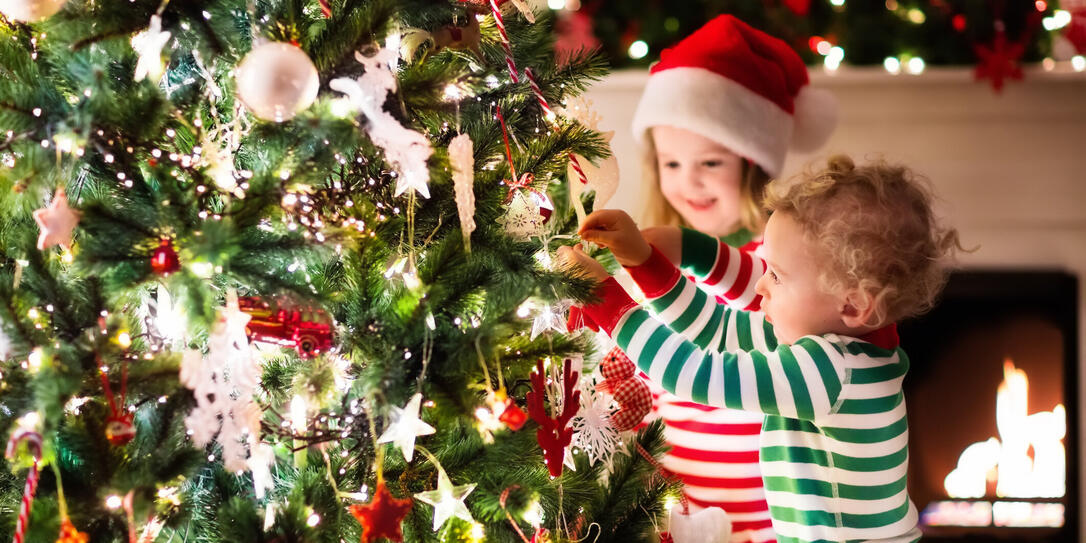 Kids decorating Christmas tree in beautiful living room