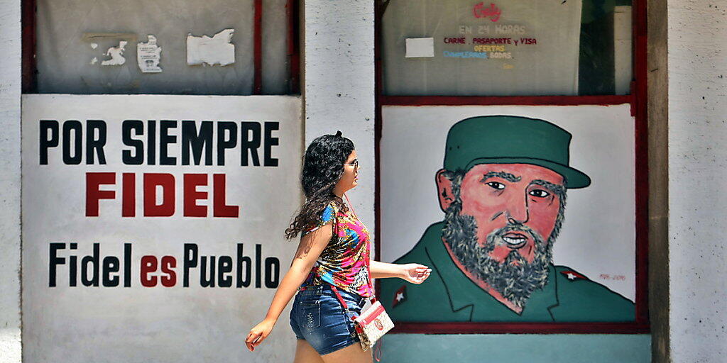 Für immer Fidel - Fidel ist das Volk. Die Kubanerin in Havanna scheint der Spruch an der Hauswand wenig zu beeindrucken.