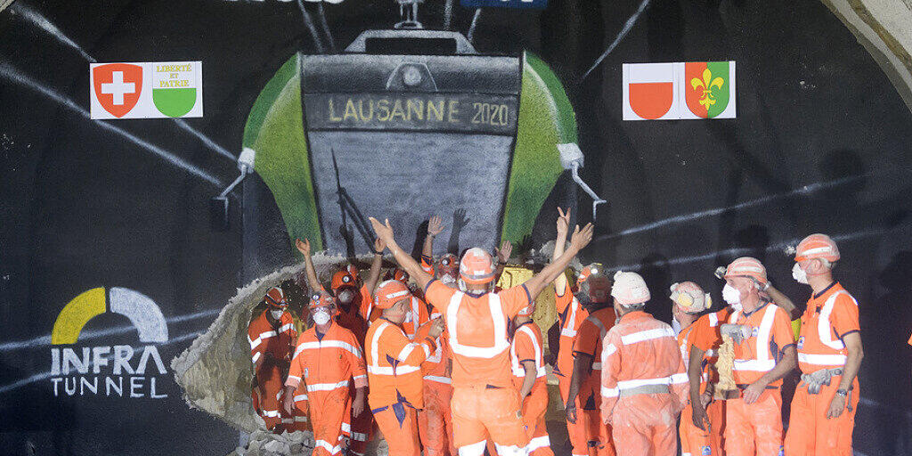 Bauarbeiter feiern den erfolgreichen Durchstich des Tunnels bei Lausanne.