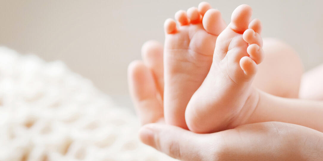 Baby feet in mother hands. Mom and her Child.
