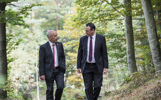 Spazierungang im Wald 30 Jahre nach der Feuersbrunst:  Bundesrat Ueli Maurer und der Liechtensteiner stellvertretende Regierungschef Thomas Zwiefelhofer.