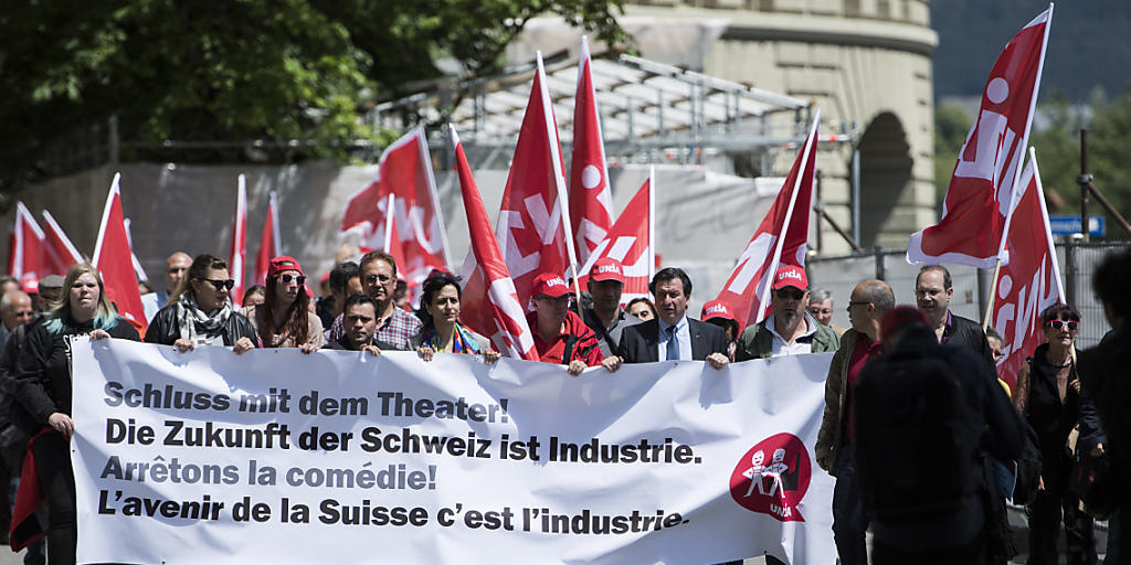 Mitglieder der Unia reichen ein Manifest zuhanden des Bundesrates ein und tragen ein Transparent mit der Aufschrift "Schluss mit dem Theater! Die Zukunft der Schweiz ist Industrie" sowie Unia-Flaggen.