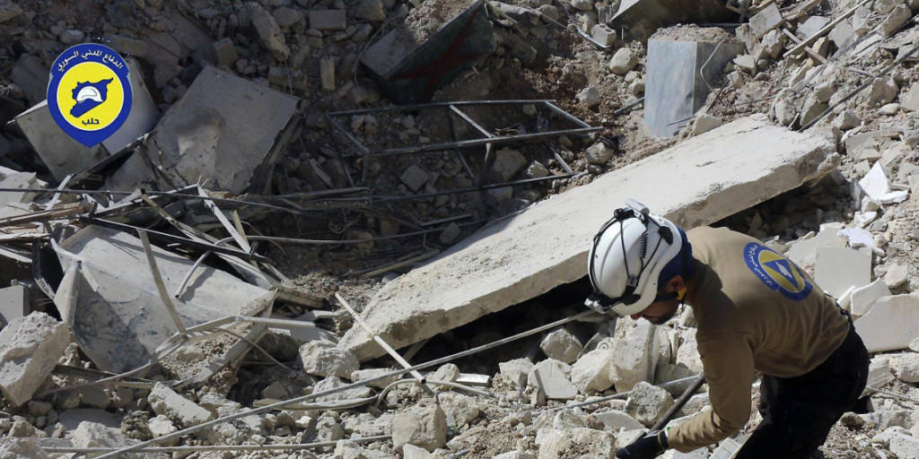 Nach Bombardierungen sucht ein Helfer im Schutt nach Überlebenden. (Archiv)