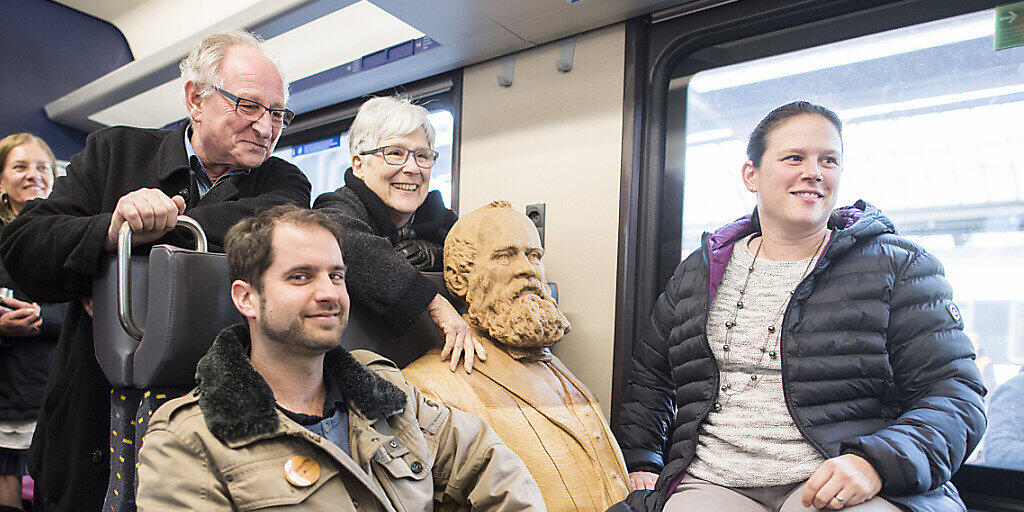 Die Schweiz ist eine Nation von Bahnfahrenden. Passagiere posieren mit einer Statue des Eisenbahnpioniers Alfred Escher. (Archivbild)