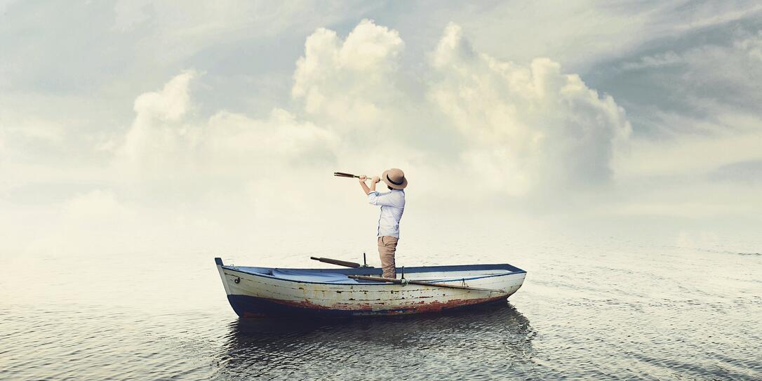 business man on a boat watching the future with binoculars