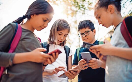 Kids playing video games on smart phone after school
