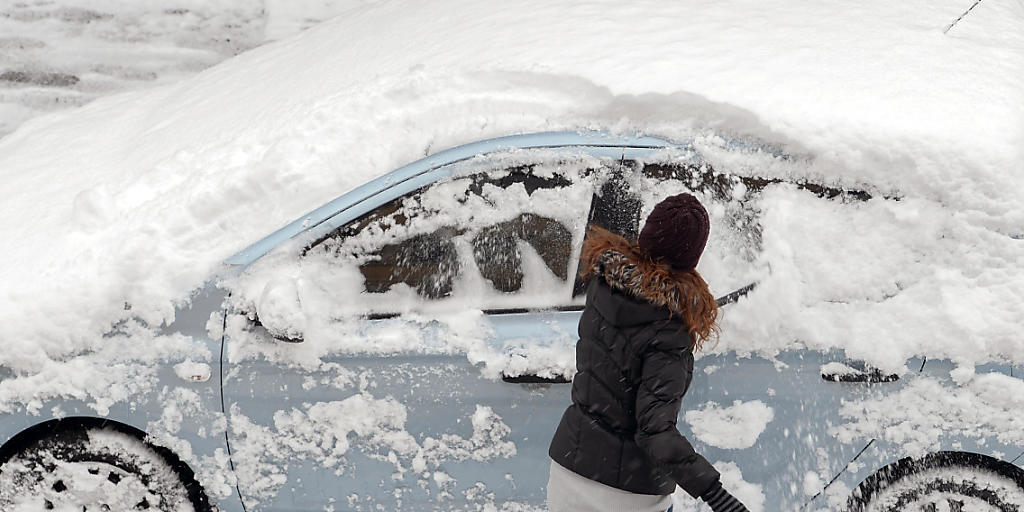 Eine Frau befreit ihr Auto vom Neuschnee: Solche Szenen könnten sich in der zweiten Wochenhälfte auch im Flachland abspielen (Archiv).