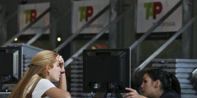Eine Frau spricht am Flughafen von Lissabon mit einer Angestellten