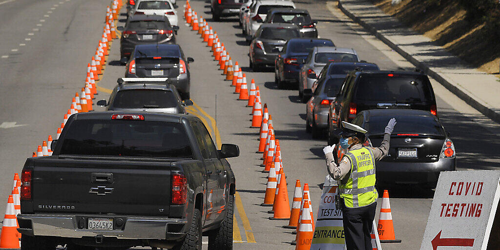 Fahrzeuge stehen vor dem Dodger Stadium in Los Angeles für einen Coronavirus-Test in einer Schlange. Foto: Mark J. Terrill/AP/dpa