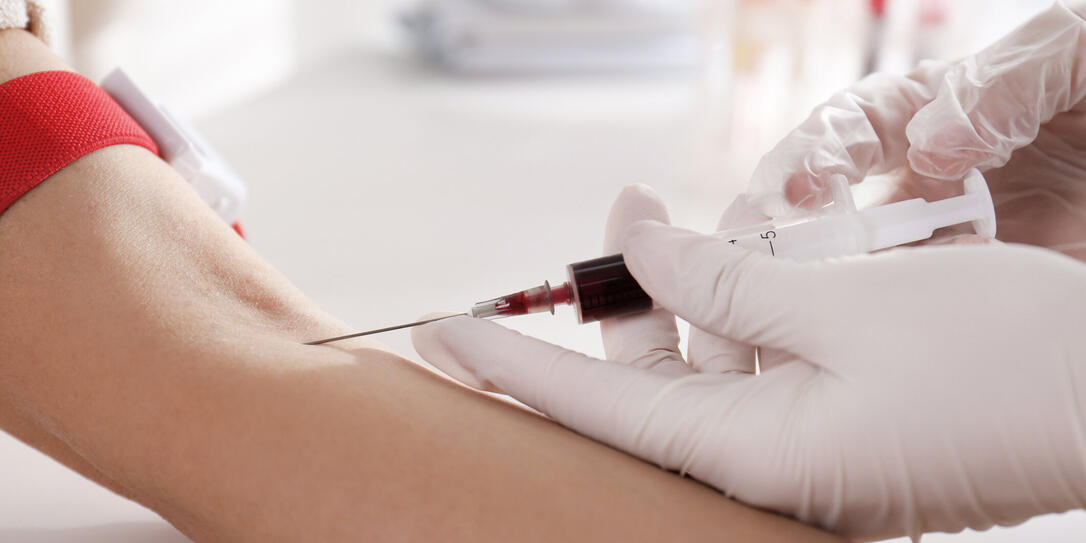 Nurse drawing blood sample from patient in clinic, closeup