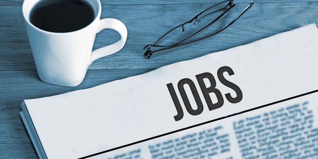 Cup of coffee, reading glasses and a newspaper with job advertisements during a job search