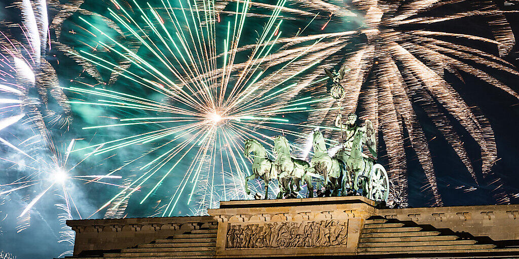 ARCHIV - Während der Silvesterparty wird am Brandenburger Tor das offizielle Feuerwerk gezündet. Die Silvesterfeierlichkeiten rund um den Globus sind wegen der Corona-Pandemie diesmal anders. Foto: Christophe Gateau/dpa