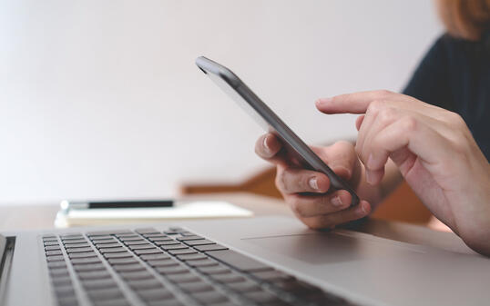 Female using smart phone during working time in office