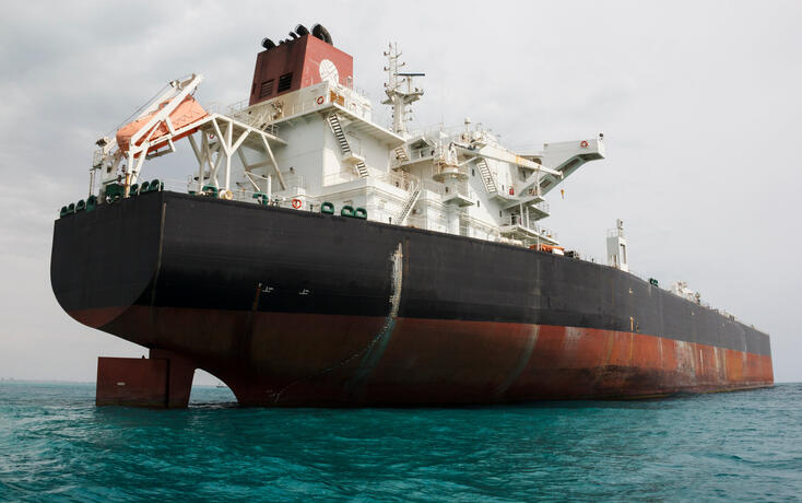 An oil tanker anchored near a petroleum terminal and offshore platform in Persian Gulf
