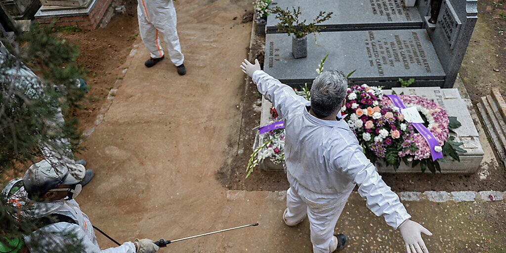 Desinfizieren auf dem Friedhof: Ein städtischer Angestellter desinfiziert einen Kollegen nach einer Beerdigung in Guadalajara.