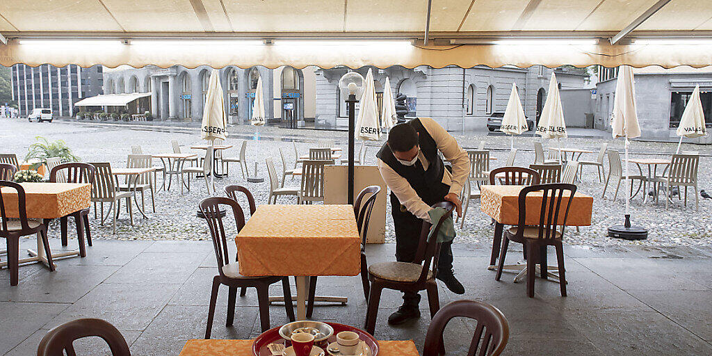 In der Schweiz werden weniger als hundert neue Corona-Fälle pro Tag gemeldet. Bei der Wiederöffnung von Cafés und Restaurants empfiehlt das Bundesamt für Gesundheit, weiterhin die Hygienemassnahmen einzuhalten. Im Bild desinfiziert ein Kellner einen Stuhl in einem Restaurant.