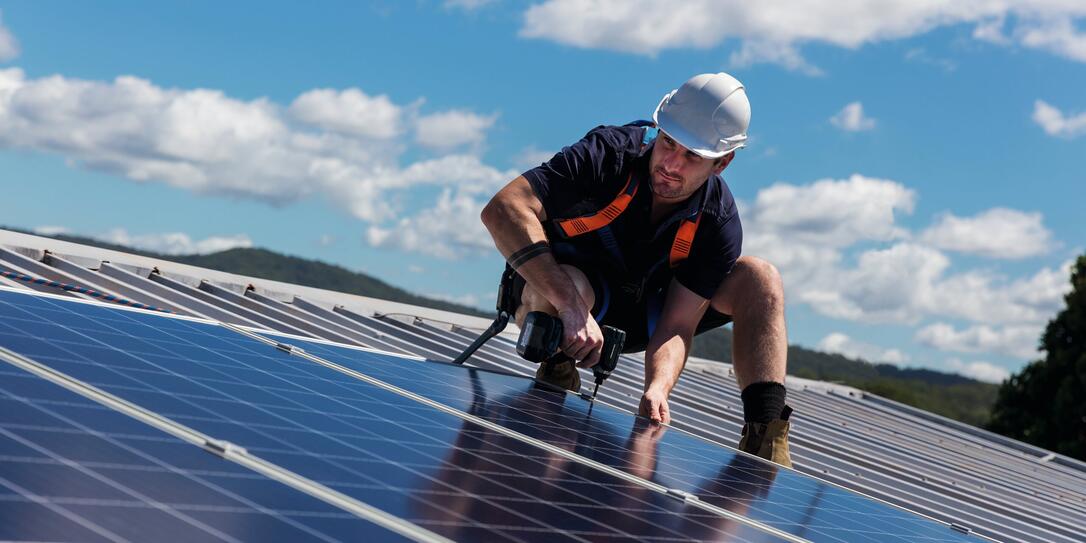 Solar panel installer with drill installing solar panels Solar panel installer with drill installing solar panels