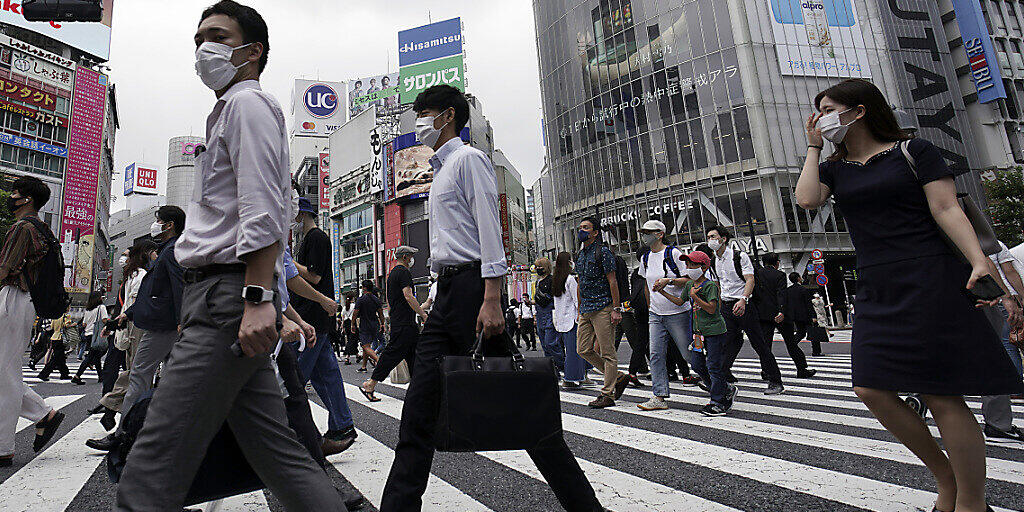 Passanten überqueren eine Straße in dem Stadtbezirk Shibuya. Japans Hauptstadt bestätigte am 31. Juli einen Zuwachs an mehr als 400 Corona-Neuinfektionen. Foto: Eugene Hoshiko/AP/dpa