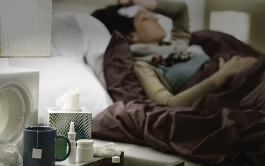 Tissue, flu medicines ill woman bedside table