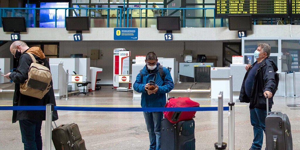 ARCHIV - Passagiere in einer Schlange im Internationalen Flughafen von Vilnius. Foto: Mindaugas Kulbis/AP/dpa