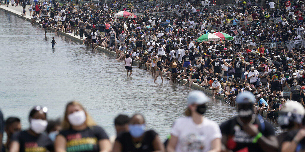 Demonstranten gehen durch den Lincoln Memorial Reflecting Pool während des 57. Jahrestages der «I Have A Dream»-Rede von Martin Luther King. Foto: Susan Walsh/AP/dpa