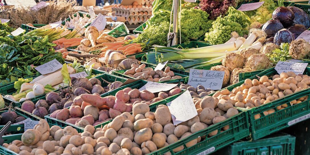 Fruit and vegetable stand with fresh regional products and price tags in German language Fruit and vegetable stand with fresh regional products and price tags in German language