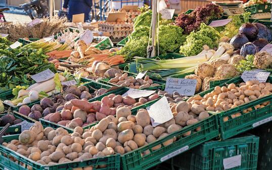Fruit and vegetable stand with fresh regional products and price tags in German language