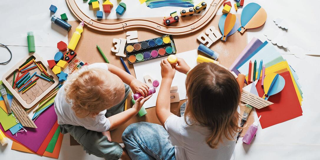 Children drawing and making crafts in kindergarten or daycare.